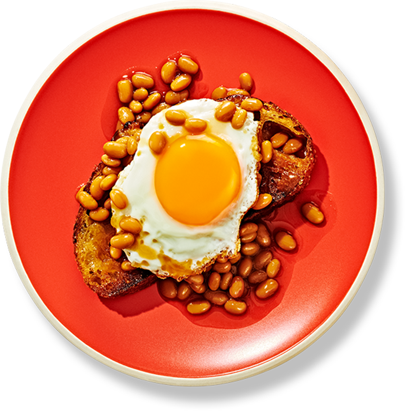Sunny side up egg on a piece of toast covered in baked beans on a red plate