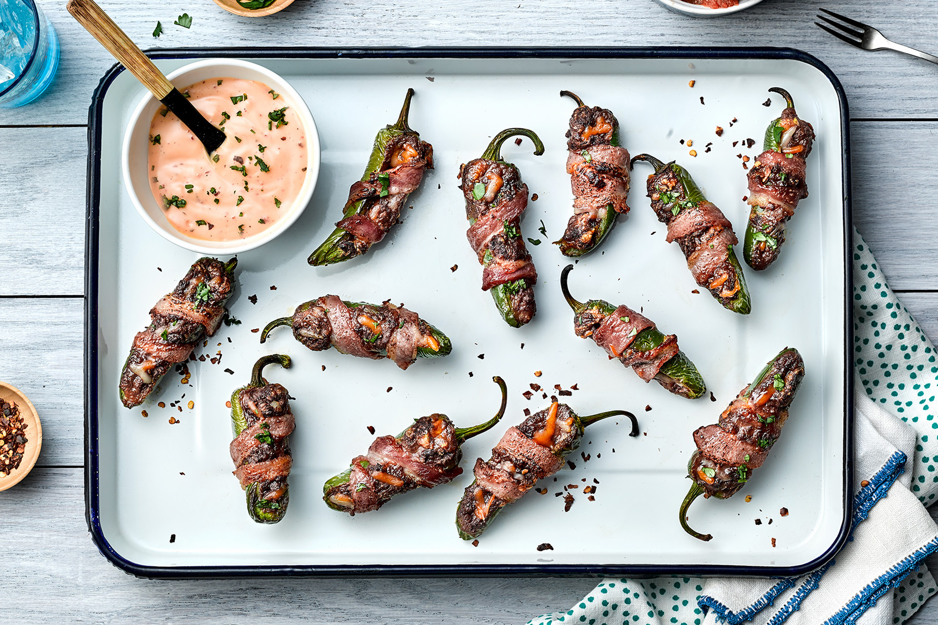 A platter of bean and cheese stuffed jalapeno poppers wrapped in bacon